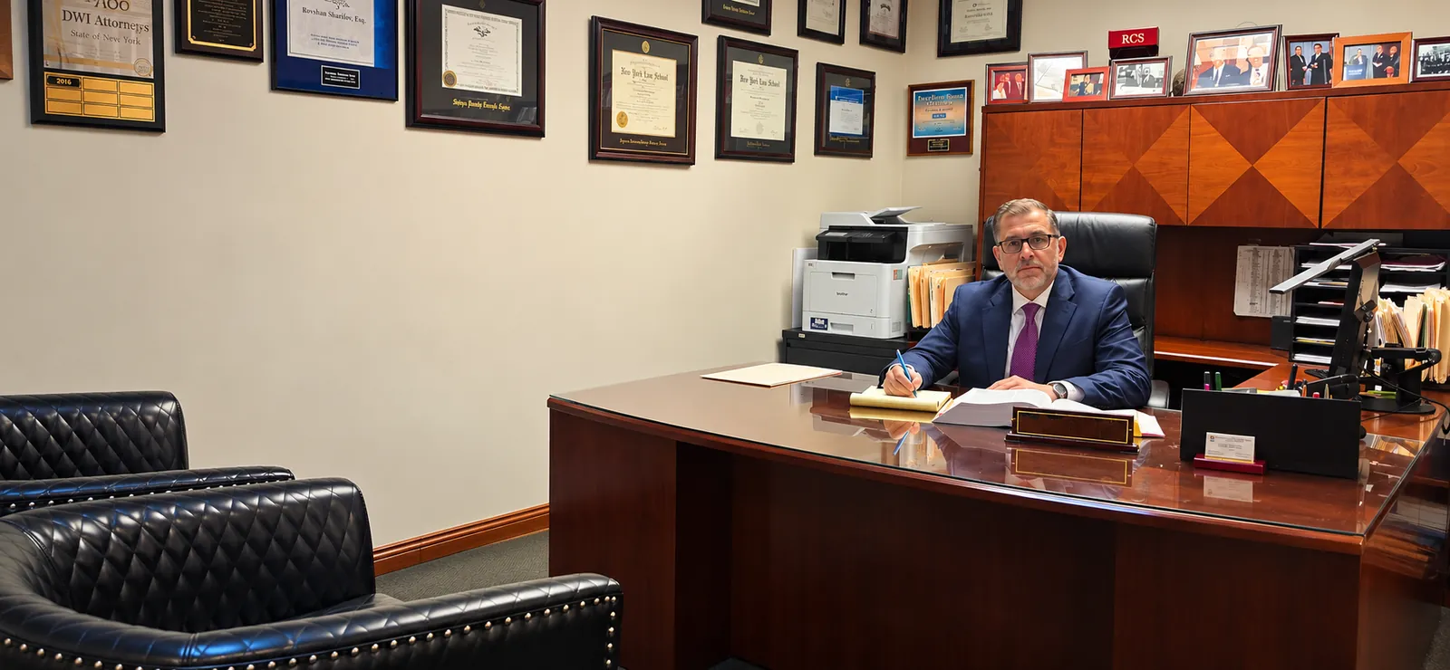 Rovshan Sharifov at his desk in the Sharifov & Associates, PLLC Hempstead office